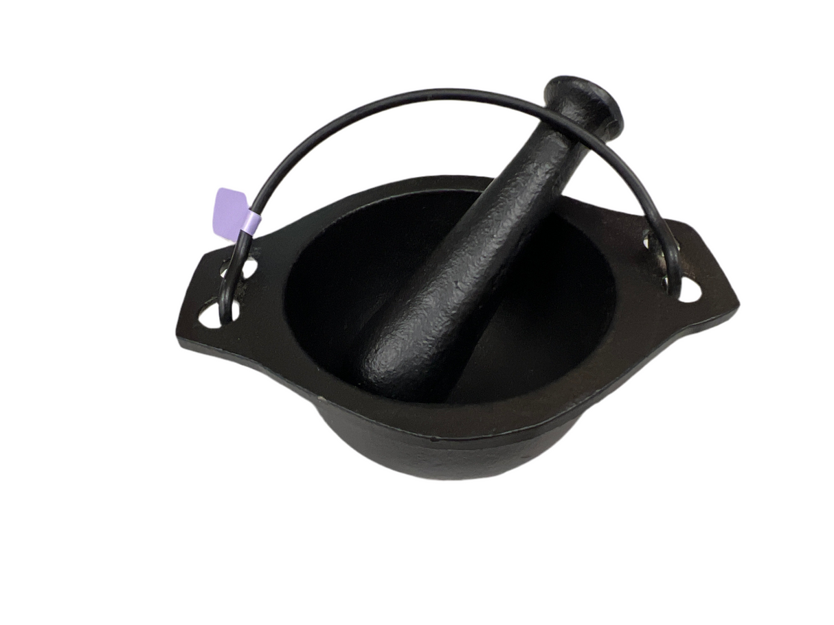 black cast iron cauldron with a pestle