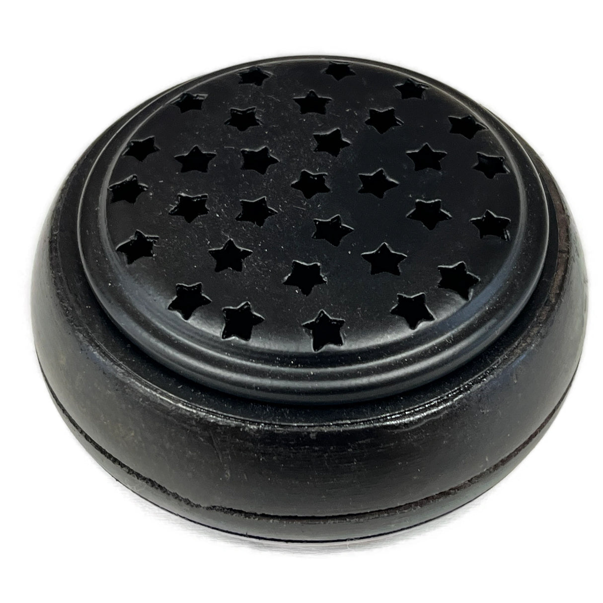 Round metal container with a metal top with little star-shaped holes.