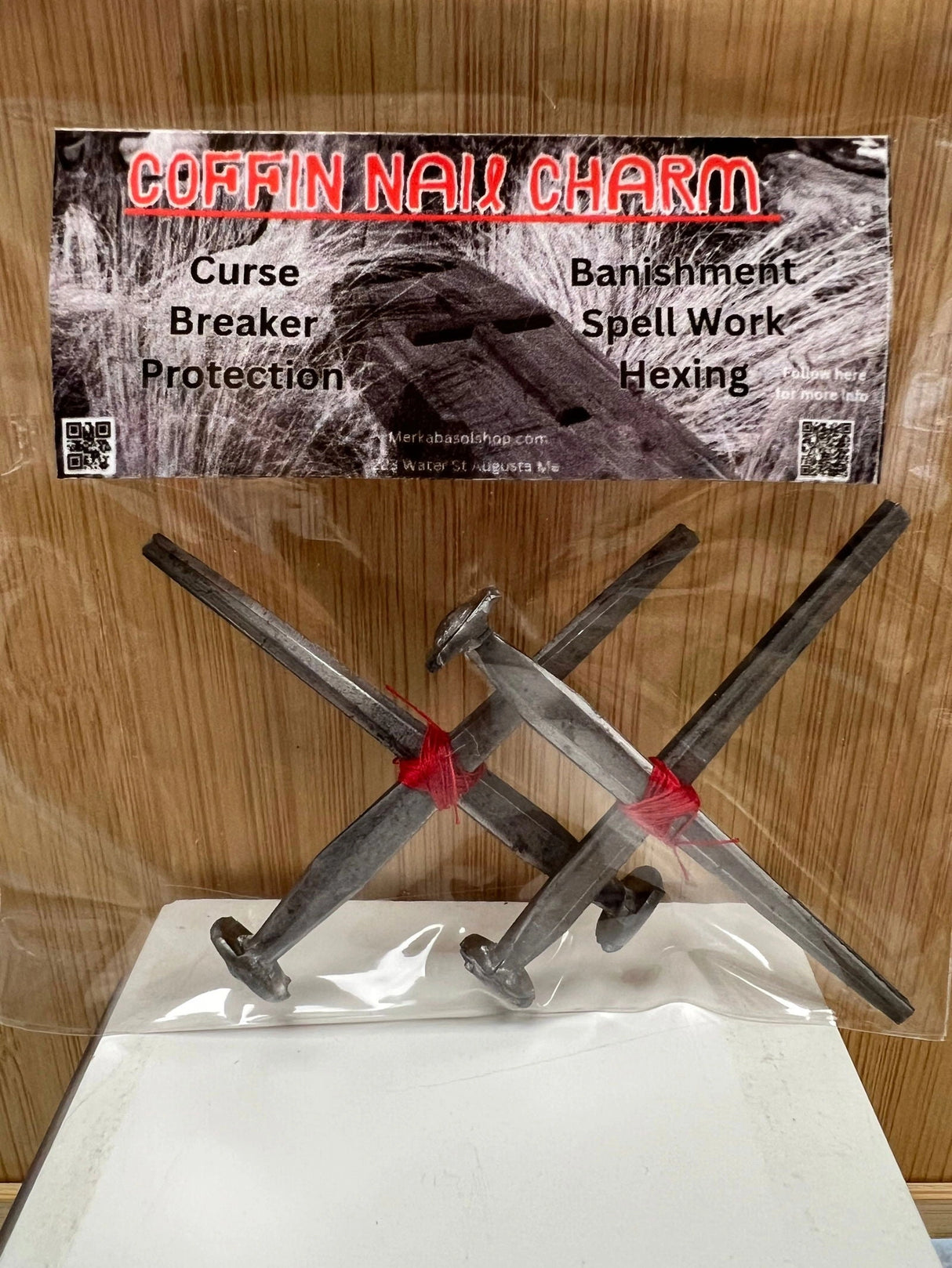 Four rusty, crossed coffin nails tied together with red strings