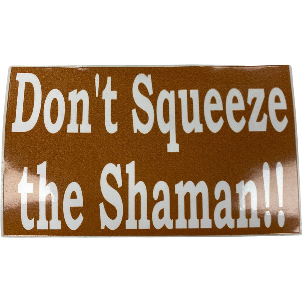 Don't Squeeze the Shaman sticker, brown background with white text.