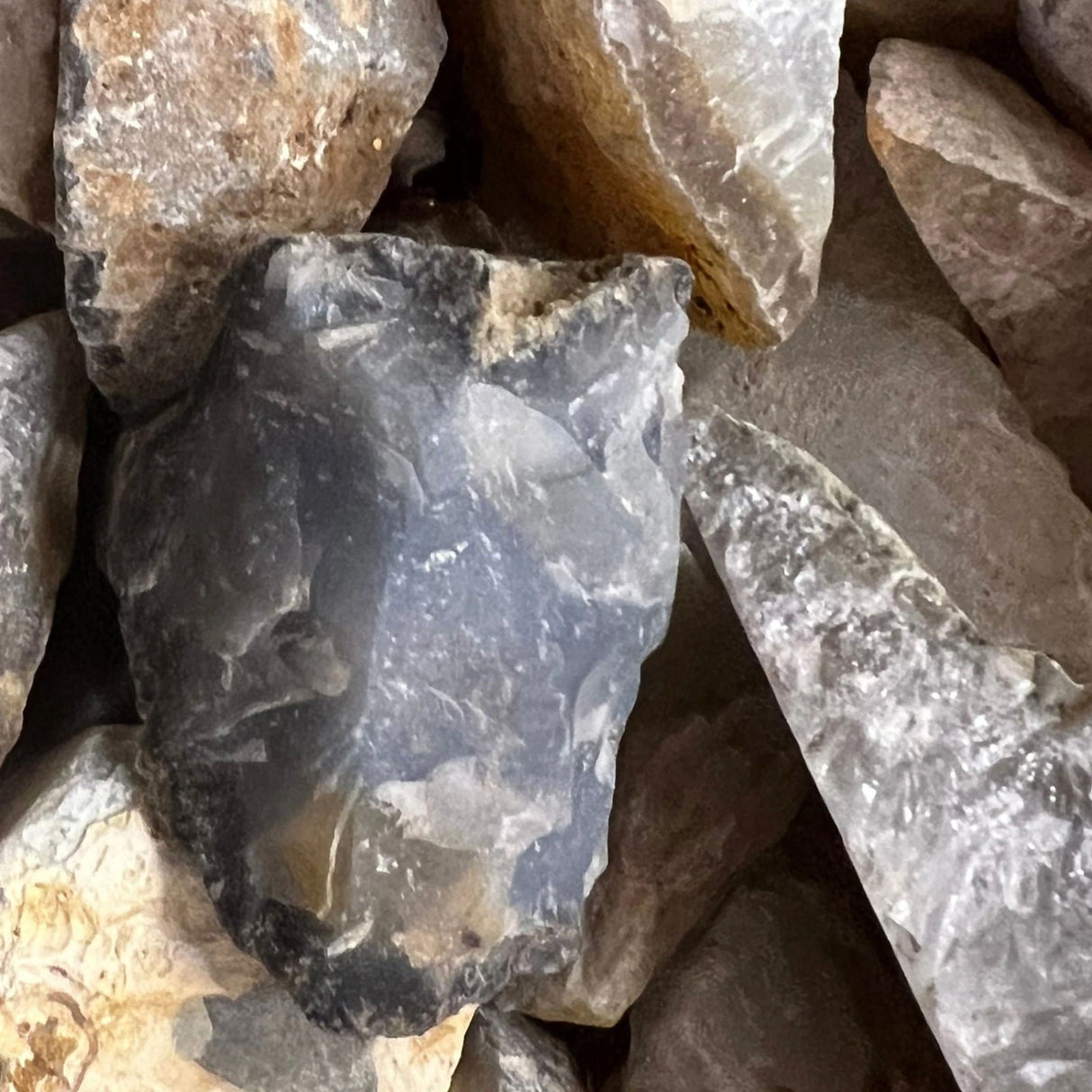 Raw Agate stones in various shades of gray and brown with a rough, natural texture.