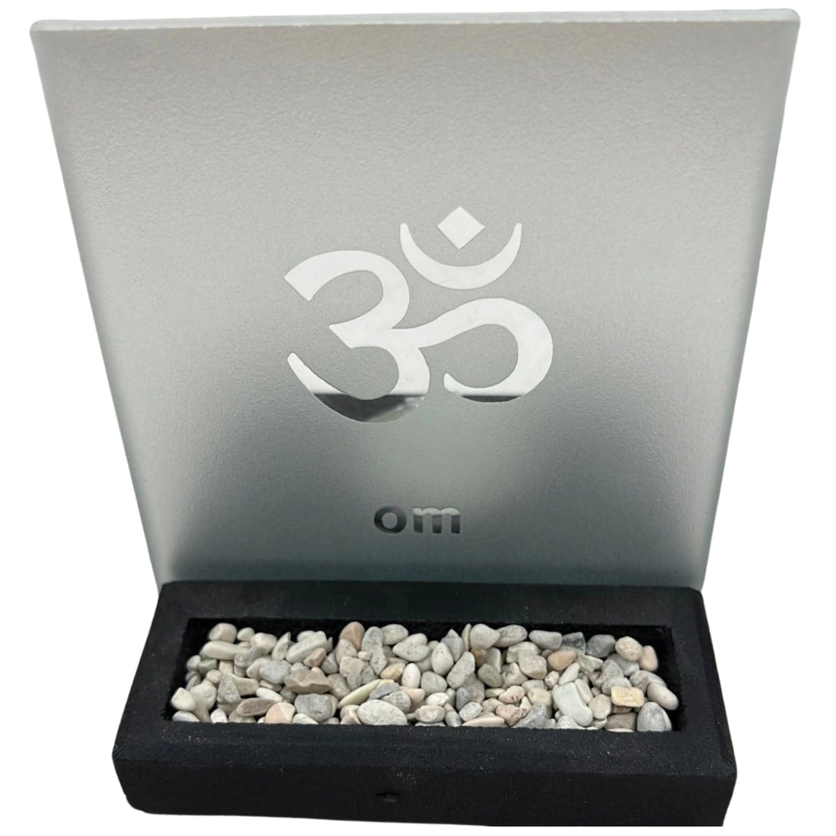 Glass candle holder with an etched Om symbol and a black base filled with white stones.