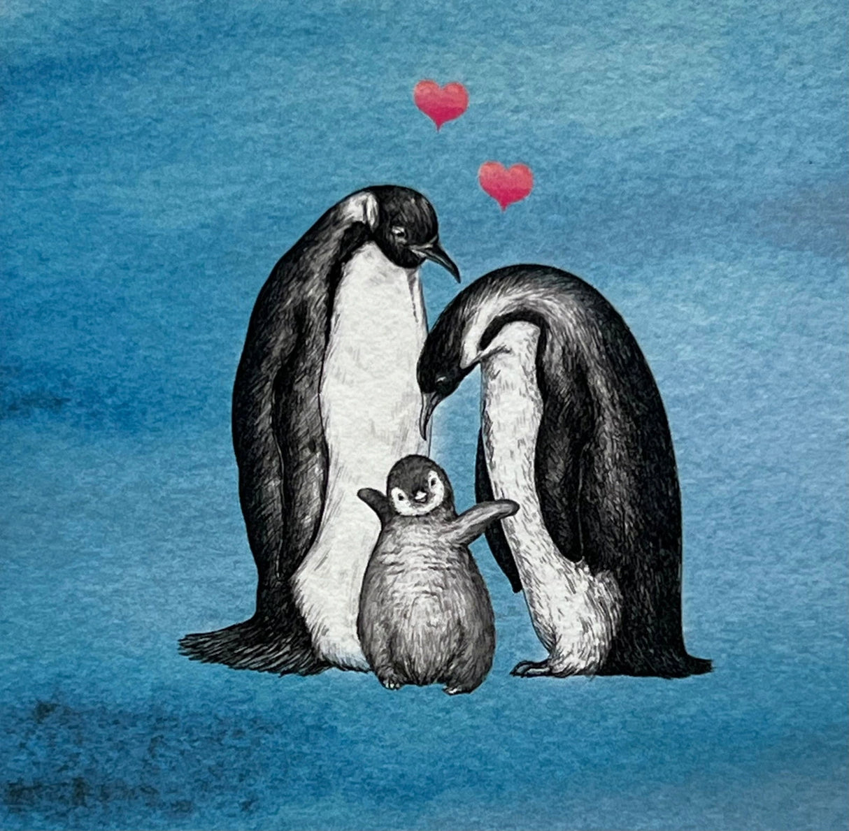 Penguin family magnet with two adult penguins and a baby penguin, surrounded by hearts.