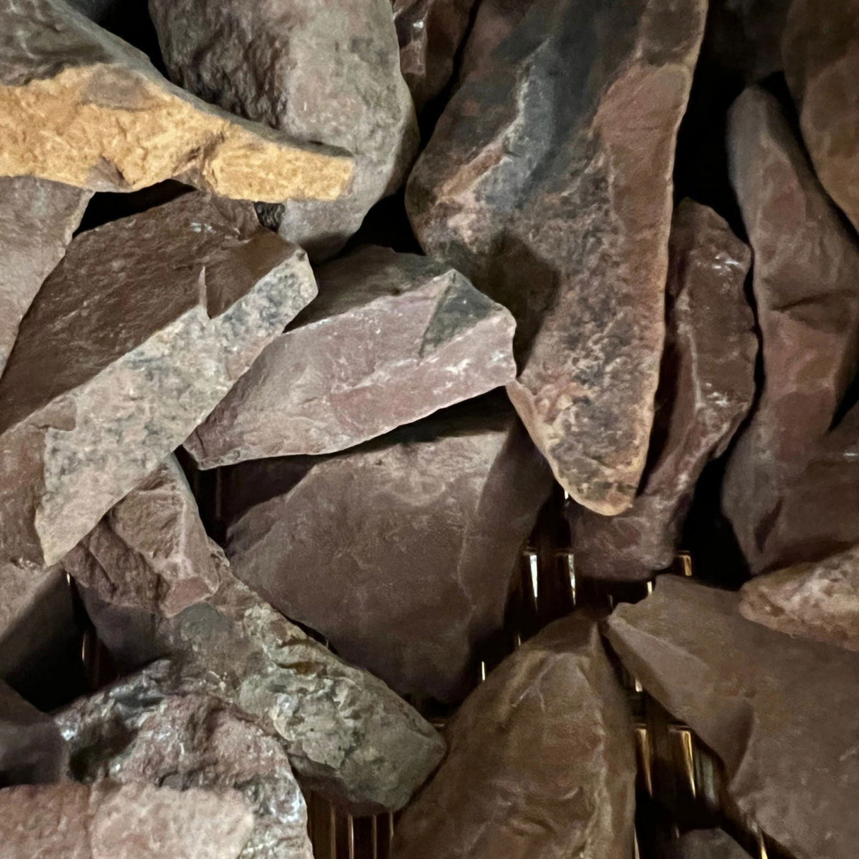 Raw Red Jasper stones with a rough, natural finish and a variety of red hues.