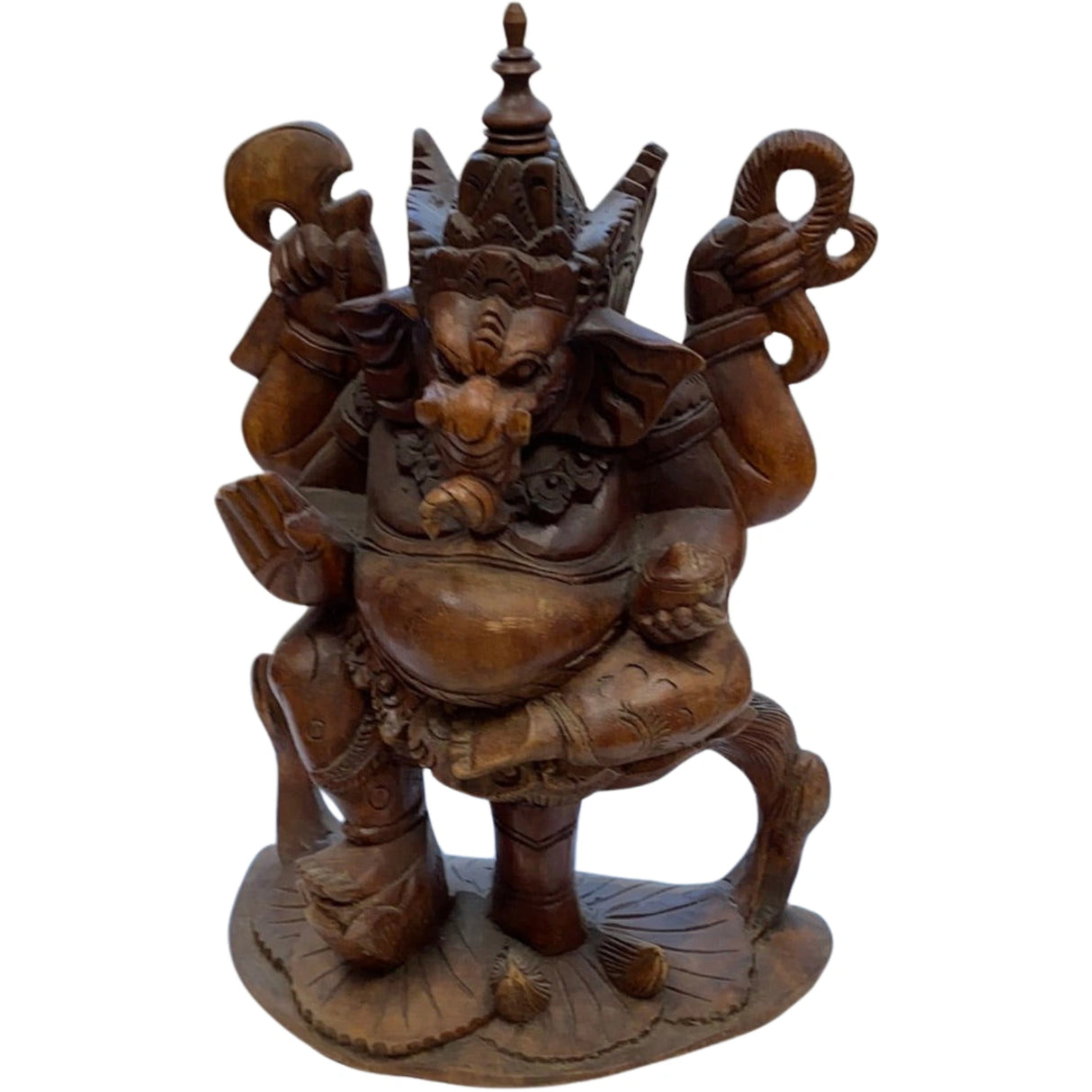 Wooden statue of Ganesha with multiple arms and objects, standing on a lotus base.