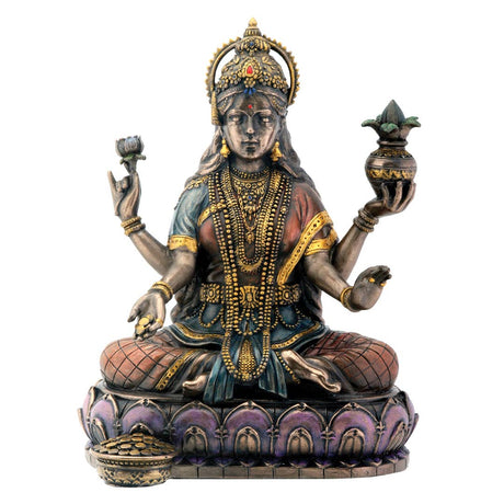 Decorative statue of a seated figure with intricate jewelry and holding objects on a white background