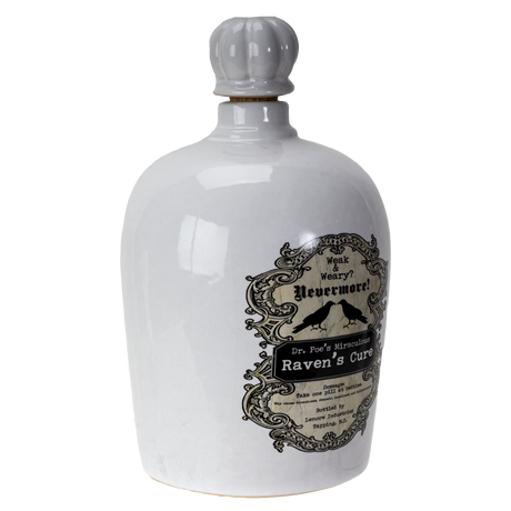 A white ceramic bottle with a ribbed gray stopper and a vintage-style black label reading 'Wink's Weirdity's Nevermore! Dr. Fun's Alchemy Raven's Cure'.