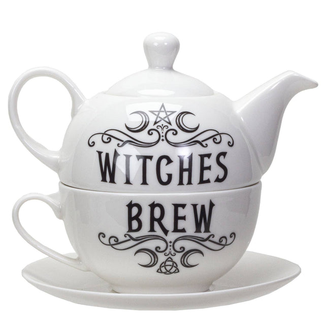 White ceramic teapot and matching teacup with saucer, featuring black gothic-style text reading 'WITCHES BREW' with decorative swirls and a pentagram symbol.