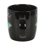 Black mug with mermaid designs on a white background