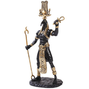 Statue of an Egyptian god with black and gold coloring on a white background