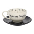 Ceramic cup and saucer set with 'Mysterious things see' text on a white background