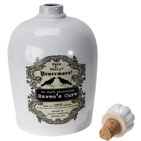 A white ceramic bottle labeled 'Raven's Cure' with a vintage-style black label featuring ravens and gothic text, shown alongside a small detached white stopper with a cork on a white background.