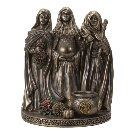 Bronze figurine of three hooded figures with a cauldron and flowers on a white background