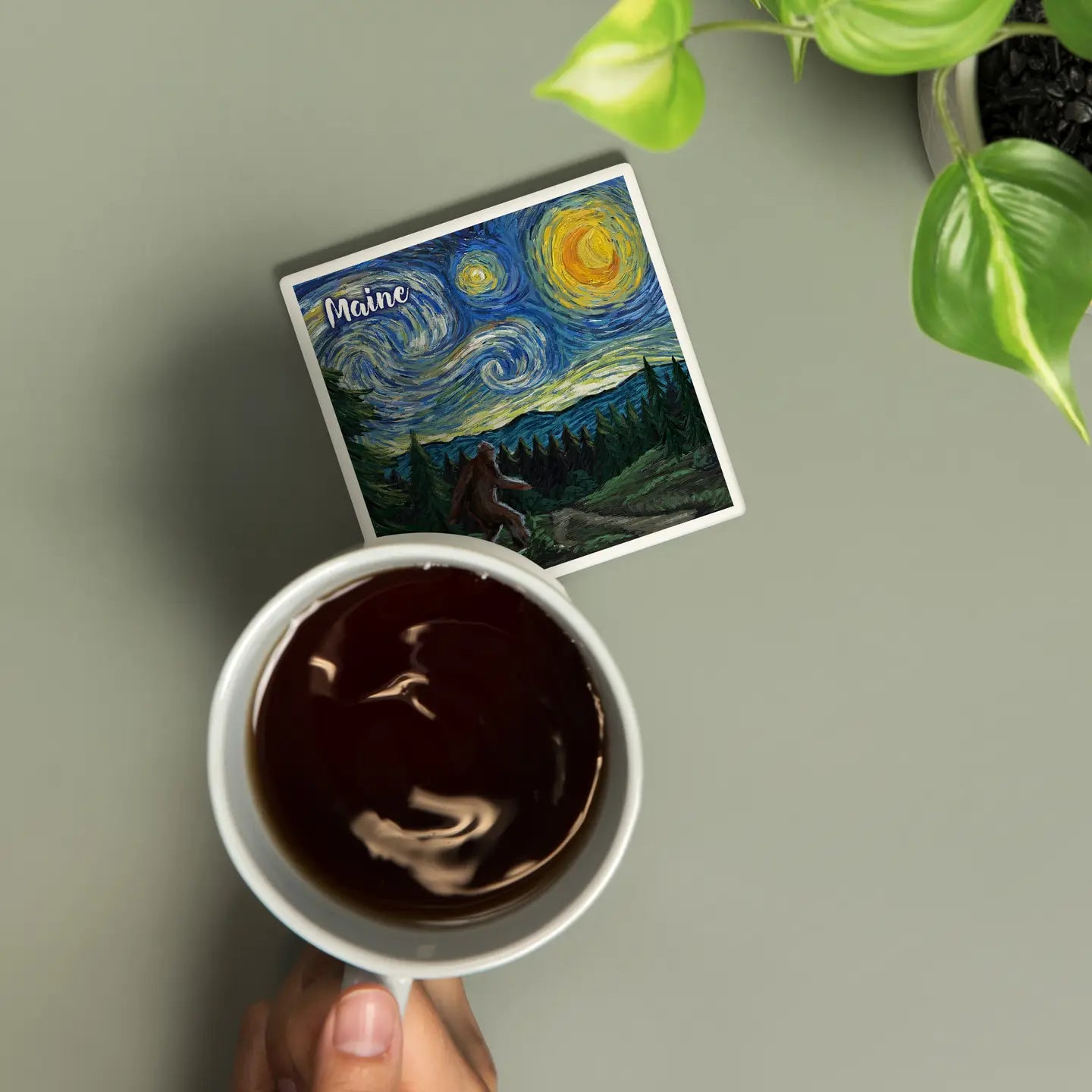 Bigfoot Starry Night Maine Ceramic Coaster and cup of coffee