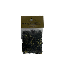 Black Ethiopian Resin transparent bag filled with dark resin held together with gold cardboard label 