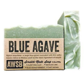 Blue bar soap with a textured surface and a label that reads "Blue Agave," "Scratch Made Soap," and "AWSB." The label also includes information about the ingredients and their benefits.