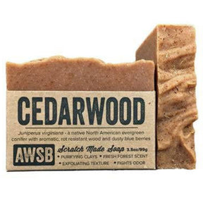 Brown bar soap with a textured surface and a label that reads "Cedarwood," "Scratch Made Soap," and "AWSB." The label also includes information about the ingredients and their benefits.