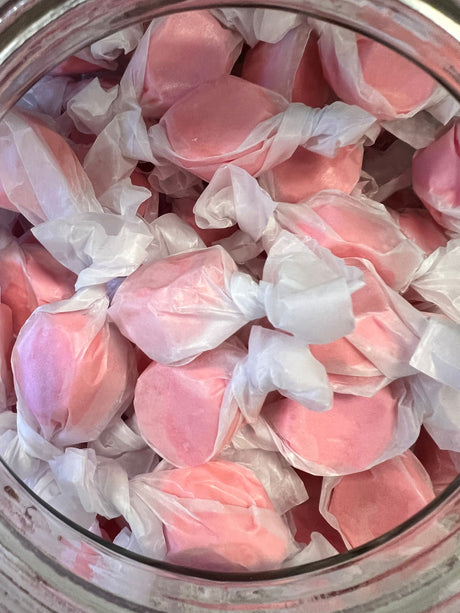 Cinnamon Salt Water Taffy - Pinkish red candy piece wrapped in wax paper 