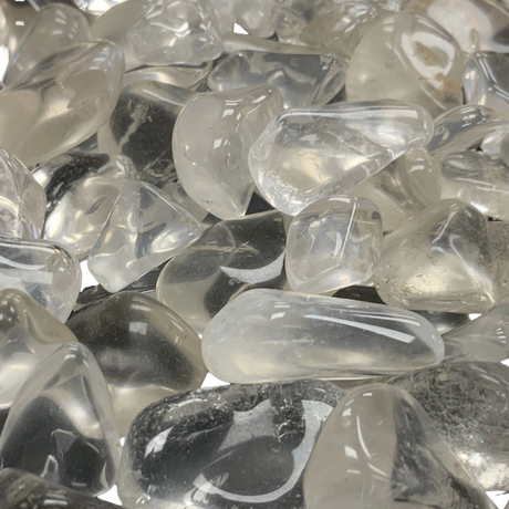 A cluster of small, tumbled clear quartz stones with a smooth, polished finish.