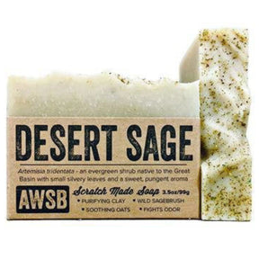 Brown bar soap with a textured surface and a label that reads "Desert Sage," "Scratch Made Soap," and "AWSB." The label also includes information about the ingredients and their benefits.