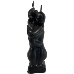 Black candle shaped like two embracing figures.