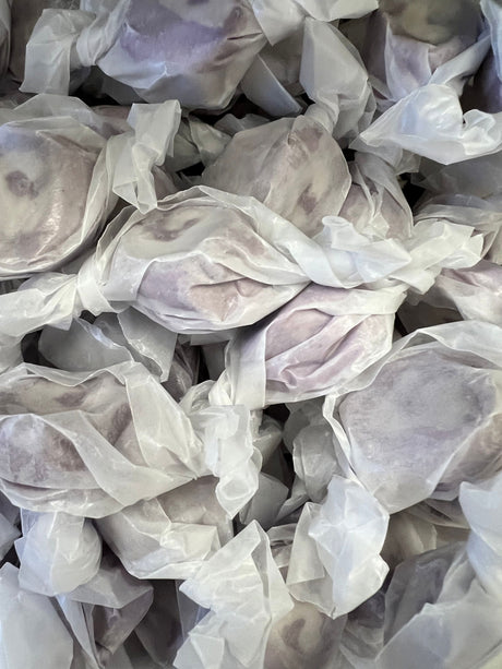 Grape Salt Water Taffy - Grape colored candy piece with white swirl center wrapped in wax paper 