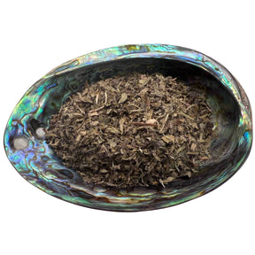 Dried Green Man Blend herb Tea in an abalone shell.