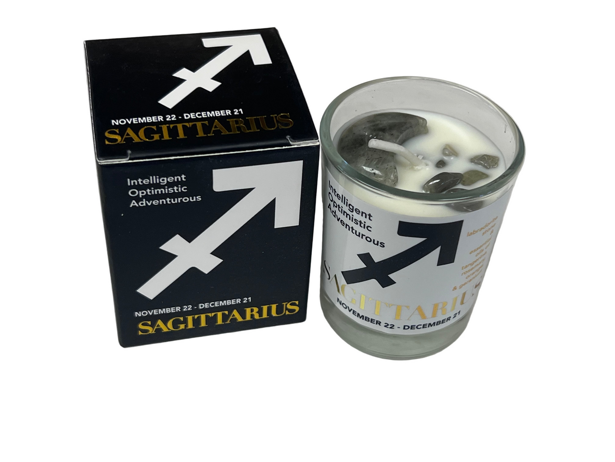 Sagittarius candle in a glass holder with packaging on a light gray background