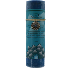 Blue candle with "JOY" label and aquamarine pendant.