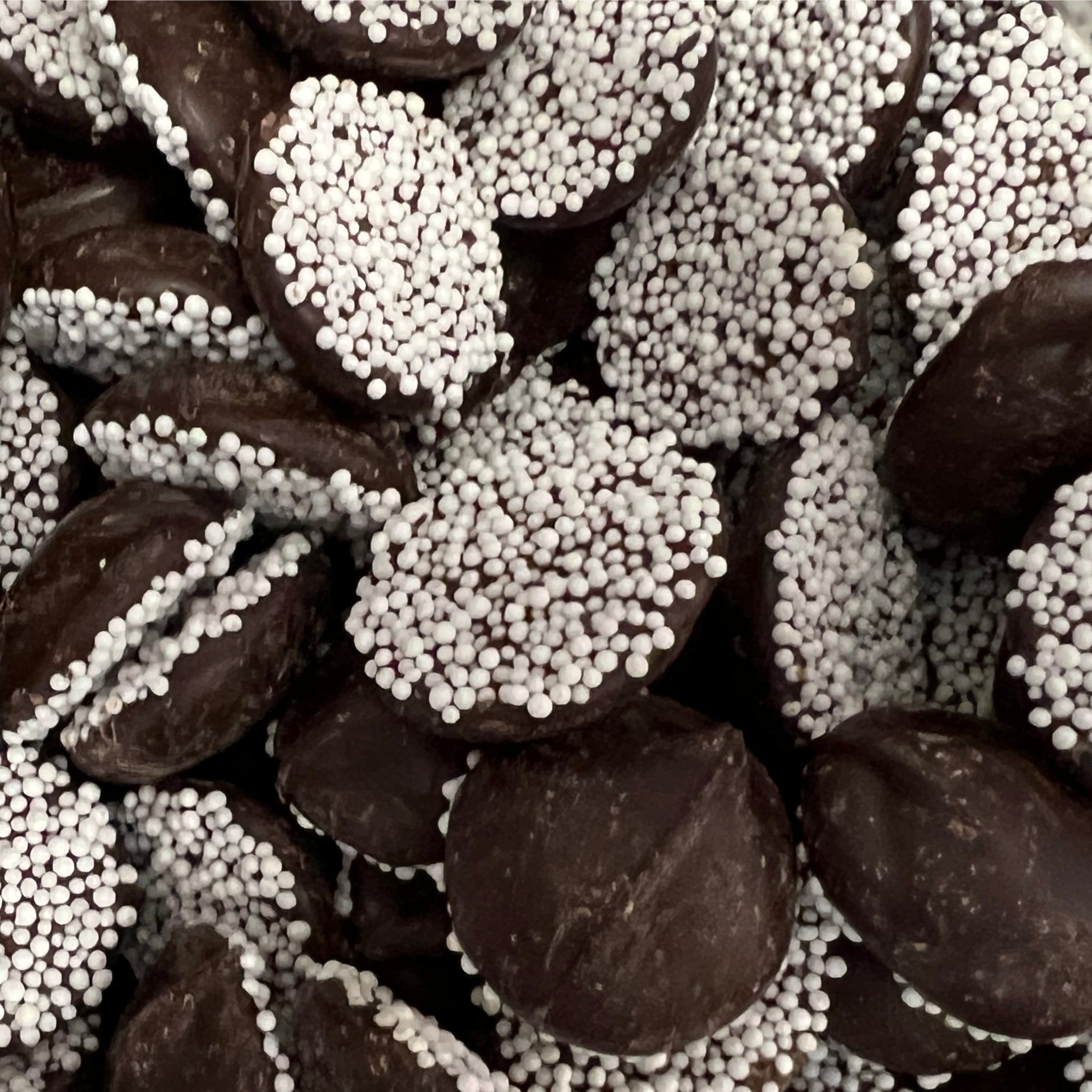 Dark chocolate disks with crunchy white  candy sprinkles 
