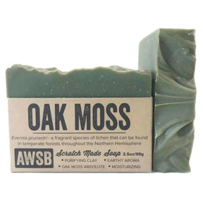 Green bar soap with a textured surface and a label that reads "Oak Moss," "Scratch Made Soap," and "AWSB." The label also includes information about the ingredients and their benefits.