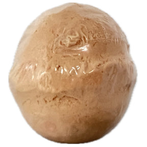 Peach-colored bath bomb with a smooth, spherical shape.