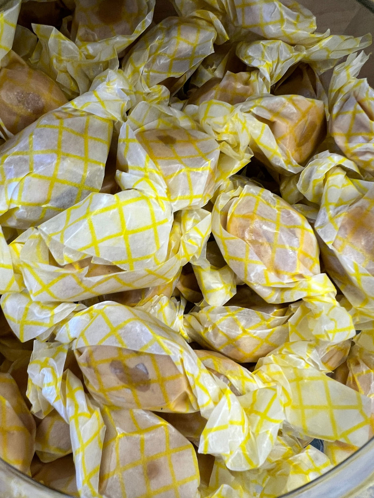 Peanut Butter Salt Water Taffy - tan colored candy with a peanut butter center wrapped in wax paper 