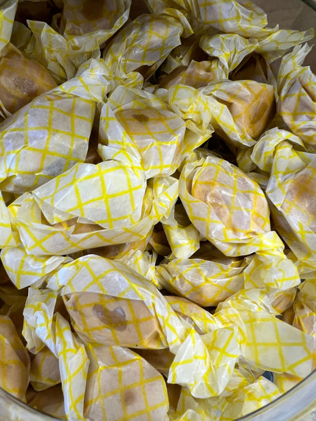 Peanut Butter Salt Water Taffy - tan colored candy with a peanut butter center wrapped in wax paper 