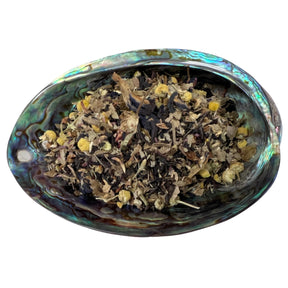 Dried Sabbat Blend Tea herbs in an abalone shell.