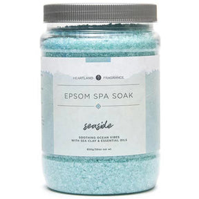 Clear plastic jar filled with blue Epsom salt crystals. The label reads "Heartland Fragrance Epsom Spa Soak Seaside Soothing Ocean Vibes with Sea Clay & Essential Oils" and includes the net weight (850g/30oz).