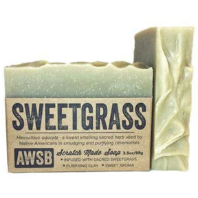 Green bar soap with a textured surface and a label that reads "Sweetgrass," "Scratch Made Soap," and "AWSB." The label also includes information about the ingredients and their benefits.