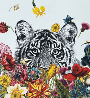 White tiger cub surrounded by colorful flowers.