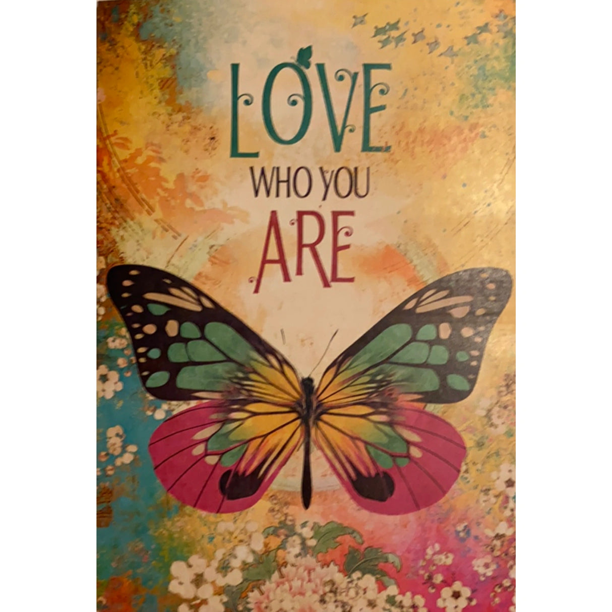 Colorful butterfly on a floral background with the text "Love who you are."