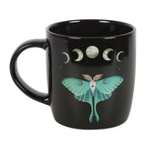 Black mug with a green moth and moon phases design on a white background