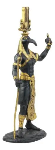 Statue of a figure in black and gold with a headdress on a white background