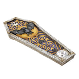 A coffin-shaped Halloween decorative tray with a small silver bowl, featuring a black bat on a gold crescent moon, a skull, and purple scrollwork on a white distressed wood-textured base.