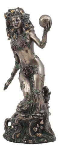 Statue of a woman with floral hair and a ball, standing on a leafy base.