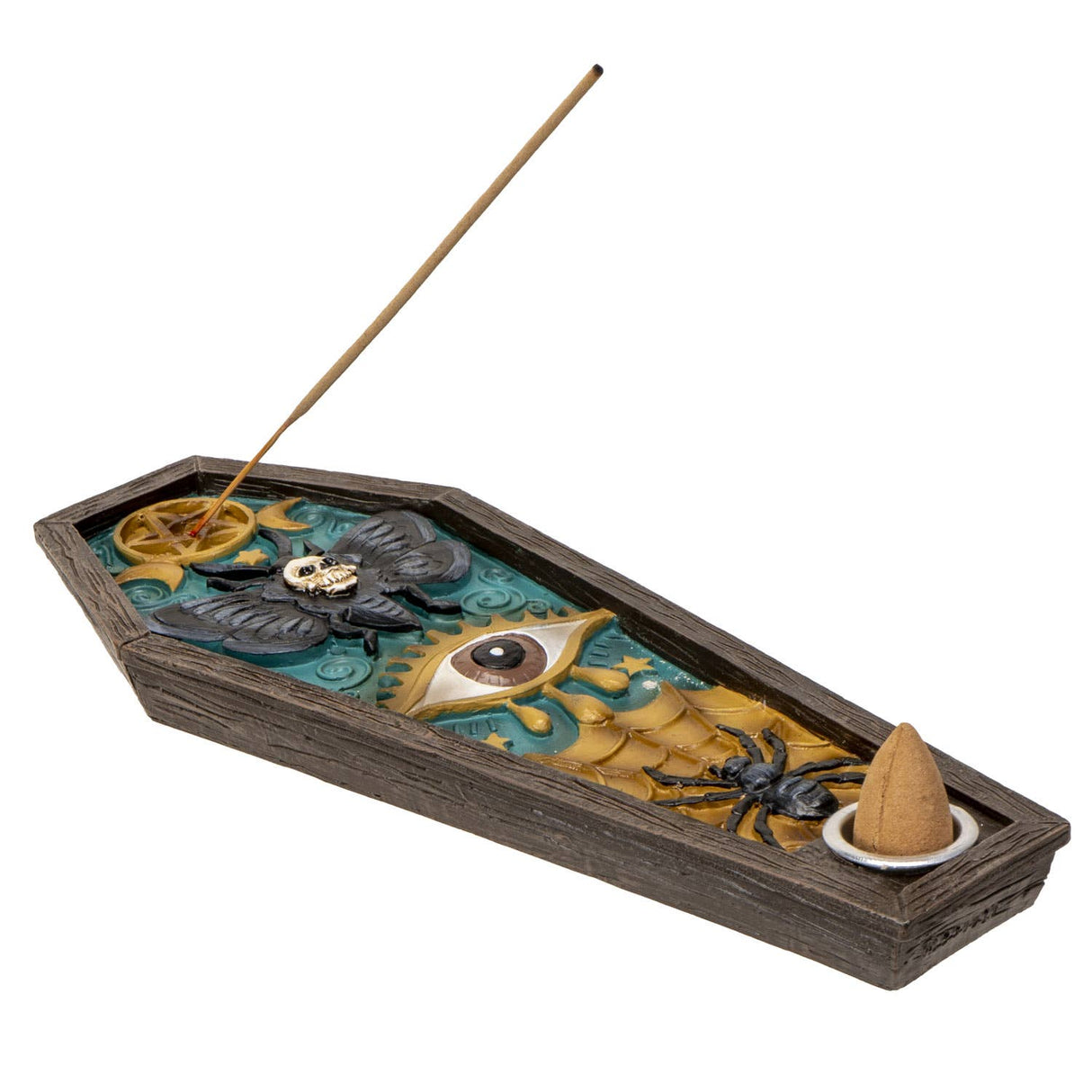 A coffin-shaped incense burner with a dark wood-look exterior and an open interior featuring a teal and gold mystical design with a large eye, black bat, spider, skull, and a small incense cone holder. A incense stick is inserted into the top opening, photographed on a plain white background.