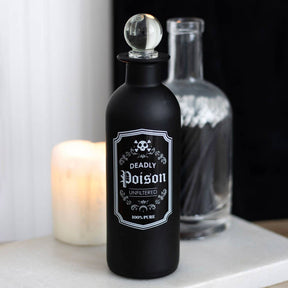 Black bottle labeled 'Deadly Poison' with a candle in the background