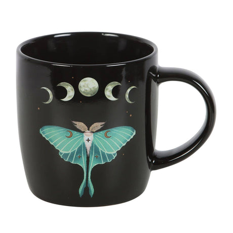 Black mug with a green moth and moon phases design on a white background