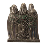 Bronze statue of three hooded figures holding a tree with a white background